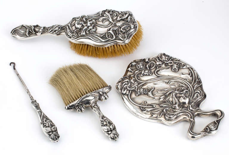 Beautifull Reposse sterling silver dresser set from the Art Nouveau period.  The design motif is flowing integration of beautiful woman's face and  her hair.  Fitting as a stunning dresser set.  The vanity set consists of  bevel hand mirror, hair