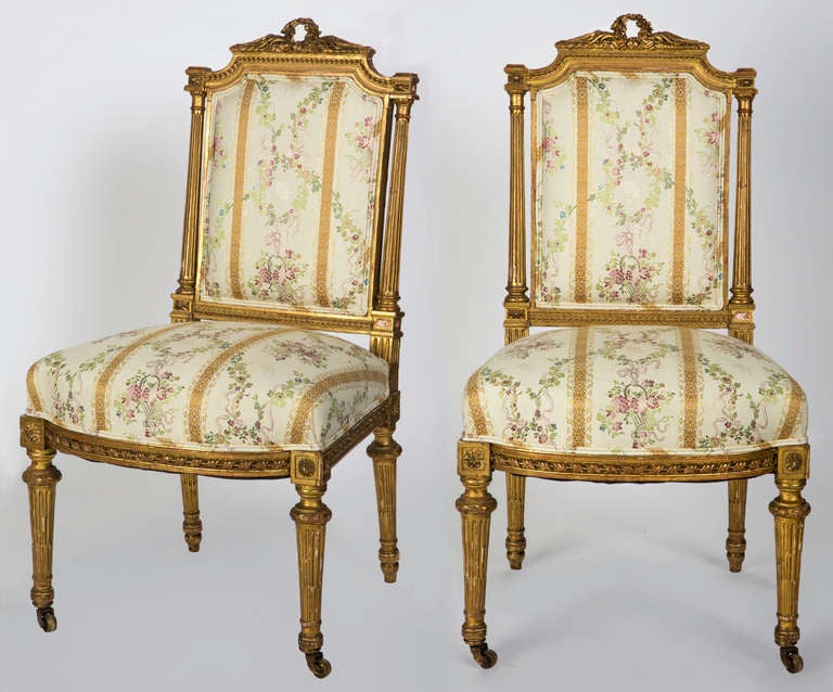 C. 1890s Louis XVI style French chairs. Gilt carved wood frame, Upholstered in floral stripe silk fabric.  Original gilt, legs on wheels.
Very comfortable.