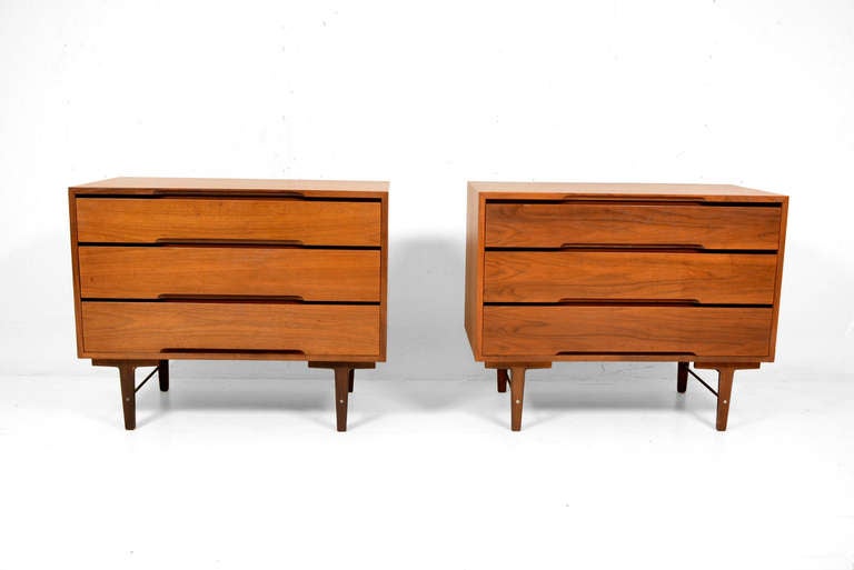 For your consideration a pair of walnut three pull out drawer dressers designed by Steward McDougal and Kipp Stewart for Glenn of California. 

Clean modern simple lines mounted in solid wood legs with bronze stretcher. 

All drawers are