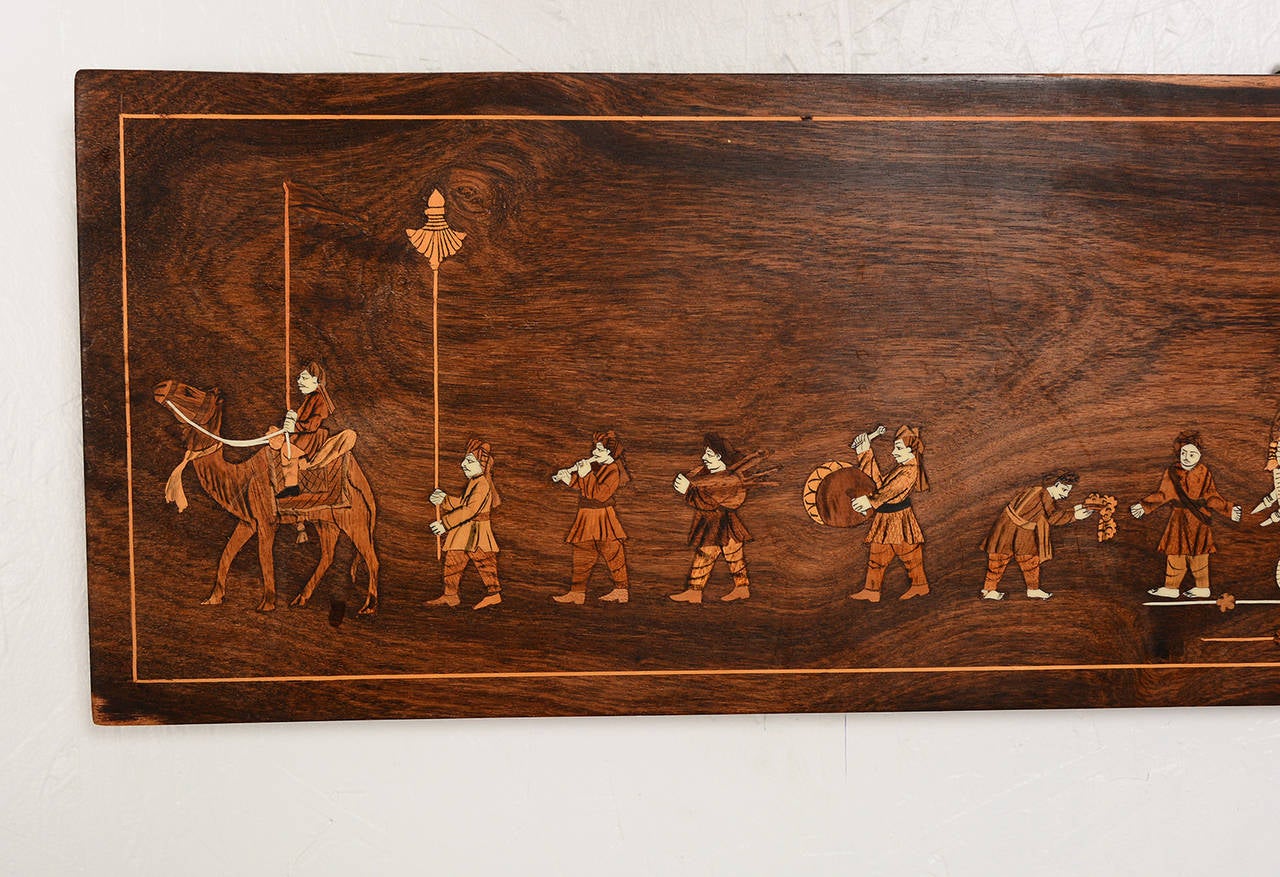 For your consideration an solid rosewood plaque with inlay displaying an India procession.

Measures: 9 " H x 24" W x 1 /2 thick.

