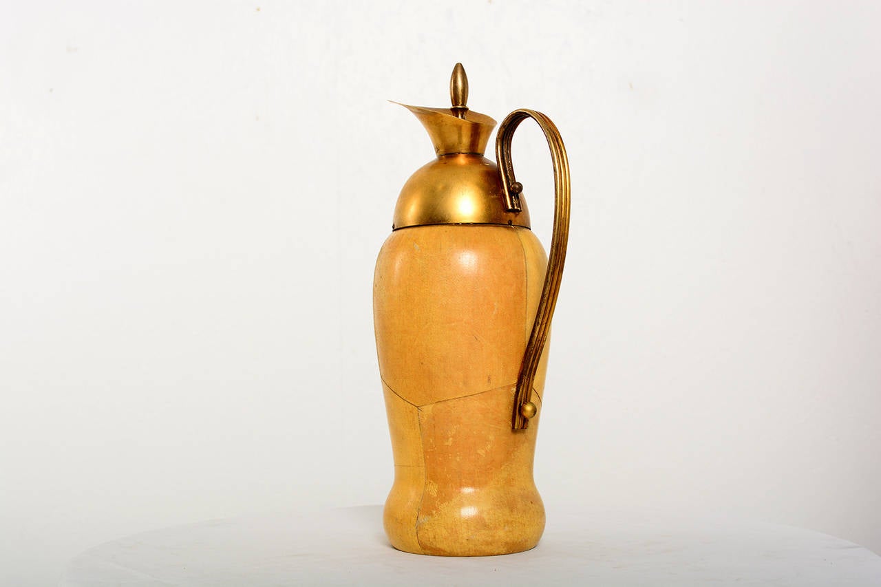 For your consideration a vintage pitcher by Aldo Tura.

Constructed with sculptural wood body wrapped in parchment. Solid brass handle and funnel.