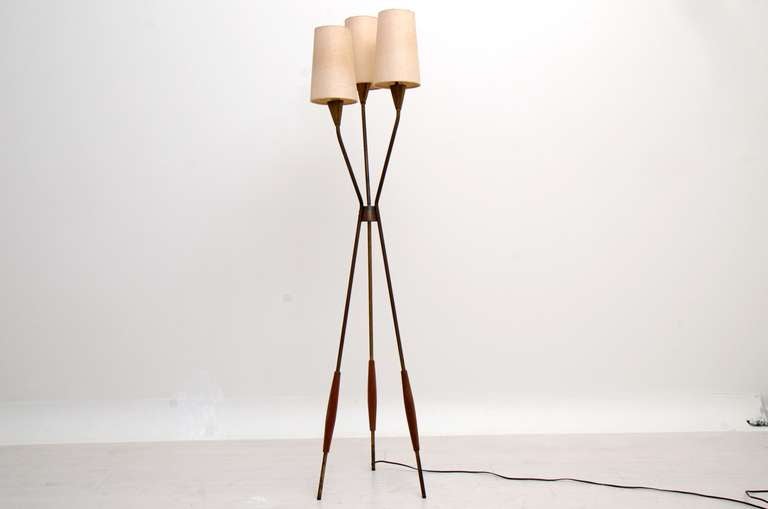A mid-century icon. Tripod floor lamp designed by Gerald Thurston for Lightolier. Brass has a vintage patina, walnut accent in the lower part of the legs. Original shades. 
