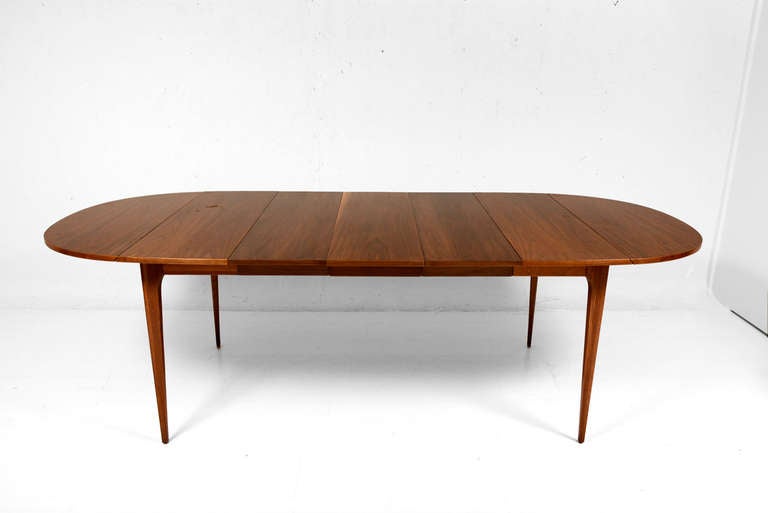 For your consideration a mid century modern long dining table with tapered legs and three extensions.

Drop leaf in both sides for multiple configurations.

Closed 60 1/4