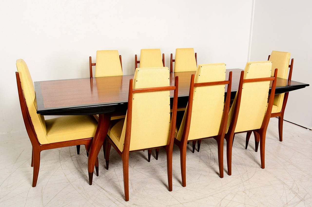 For your consideration a dining set of eight dining chairs and matching dining table. 
Chairs are unique custom built. 

Sculptural shape, constructed in solid mahogany wood. All chairs retail original oversize brass feet protectors in front.