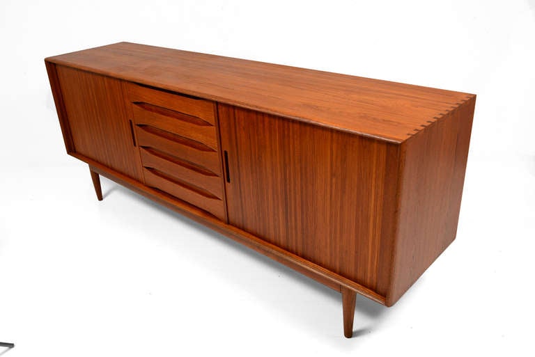 For you consideration a solid teak wood credenza with tambour doors. 
Finished in both sides. All drawers constructed with double dove tail joints. Credenza has exposed double dove tail joints in the corners. 

Tambours doors open and close with