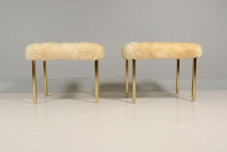 For your consideration, a pair of brass stools with lucite legs and upholstery with shearling in egg shell color.