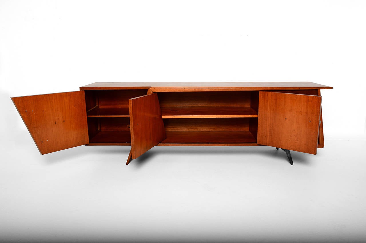 For your consideration an sculptural credenza attributed to Eugenio Escudero. 
Unique design in mahogany wood. Sculptural mahogany pull handles and solid brass handles.

The credenza has two open storage sections and three pull out drawers