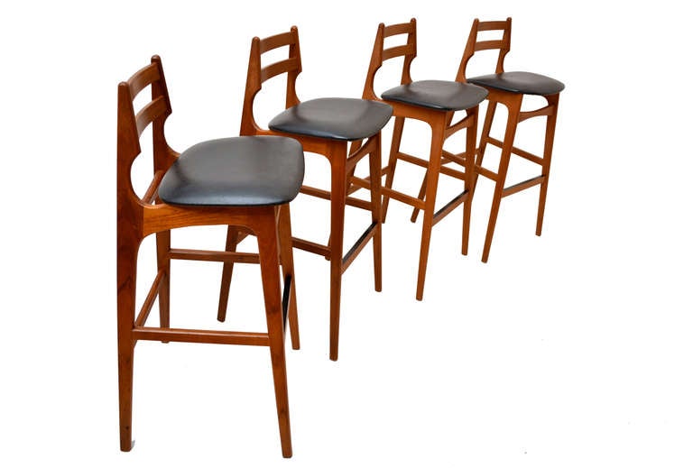 For your consideration a beautiful set of four danish modern bar stools. Sculptural shape constructed with solid teak wood. Original black naugahyde seats. Stools are in excellent condition and are ready to go. 