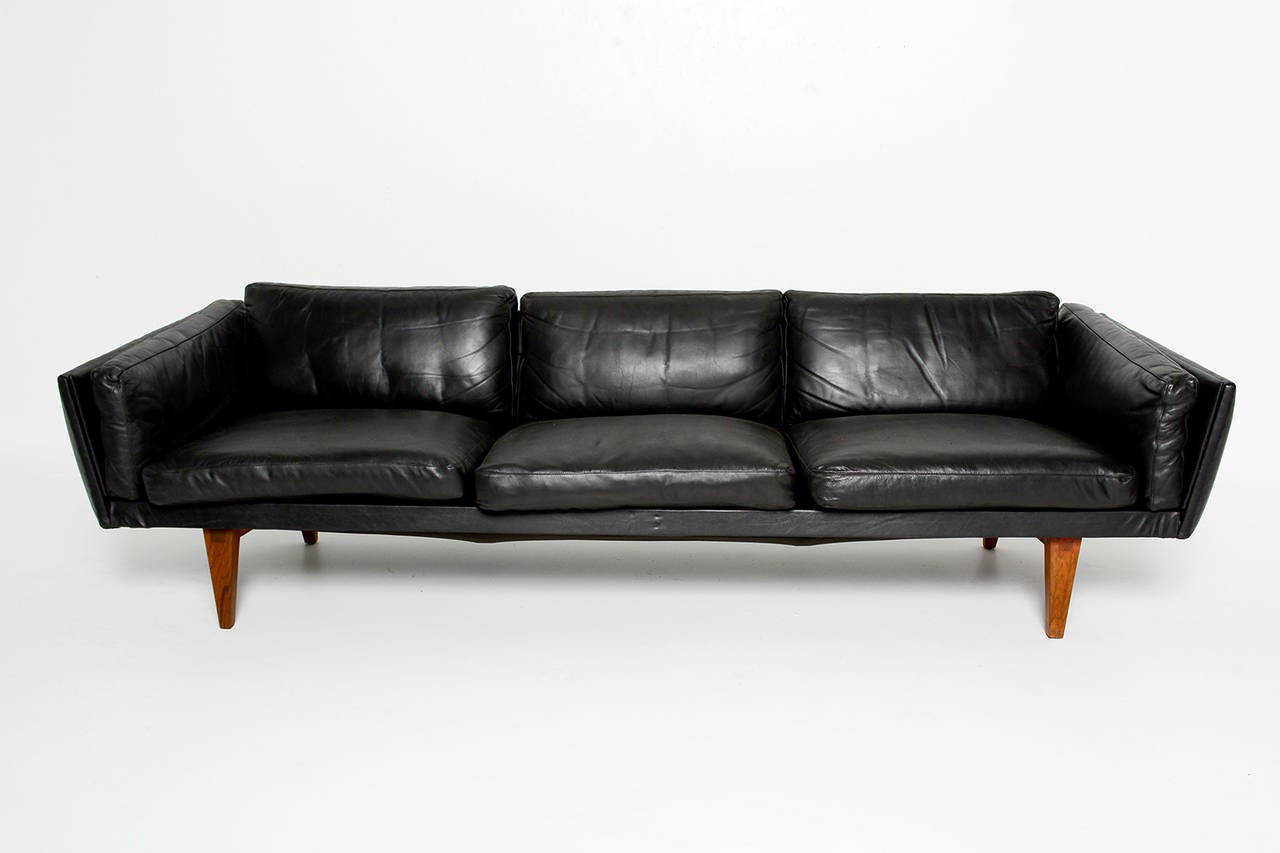 For your consideration a vintage three-seat sofa designed by Illum Wikkelso. Black leather with teak legs.

Sculptural shape. 

Dimension: 96