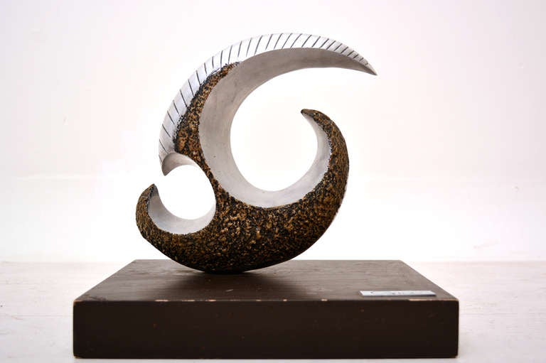 Beautiful sculpture constructed in solid aluminum with bronze on the sides. Unique shape and form. Mounted in wood base. Signed in the corner. No information about the artist is available.