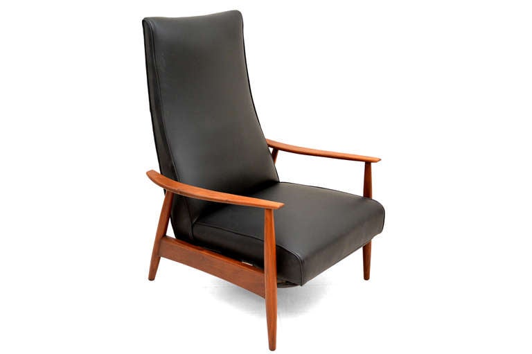 Vintage 1960s walnut recliner with new faux black leather. Designed by Milo Baughman. Sculptural wood frame. The foot rest is extends as the chair reclines back.

