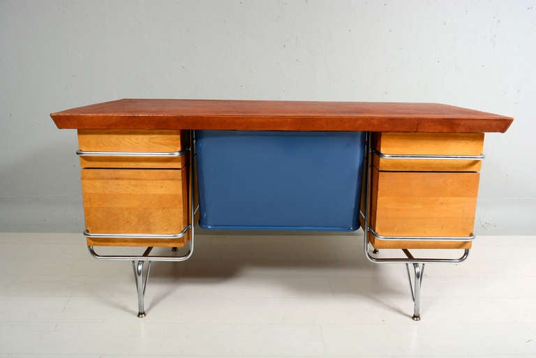 For your consideration a vintage desk designed by Kem Weber. 

Original chrome plated tubular frame with solid maple wood. 

All drawers open a close with ease. Knee hole metal guard in blue color. 

Desk top is new with new leather in brown