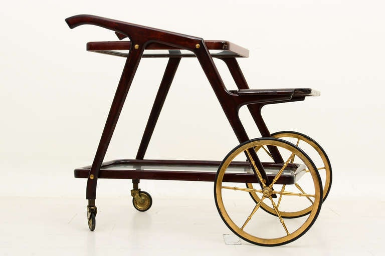 Italian service cart designed by Cesare Lacca. Very unusual and hard to find with large wheels on the front. 

Wood and glass shelves displays the beauty of the design. Amazing design which allows the card to be taken part for easy and safe