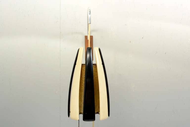 We are pleased to offer for your consideration a vintage Mid-century modern wall sconce. 

It can be hung into the wall with the wood bracket. The aluminum arm can swing into different directions and it would allow to adjust the height of the