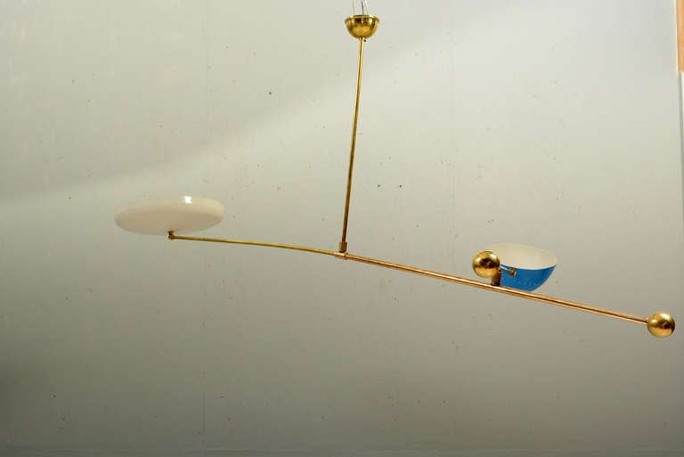 For your consideration a hanging chandelier constructed with brass and aluminum shades.  

The construction is similar to a Calder mobile with heavy brass counter weight at the end of the brass rods.  

The position of the shades can be adjusted