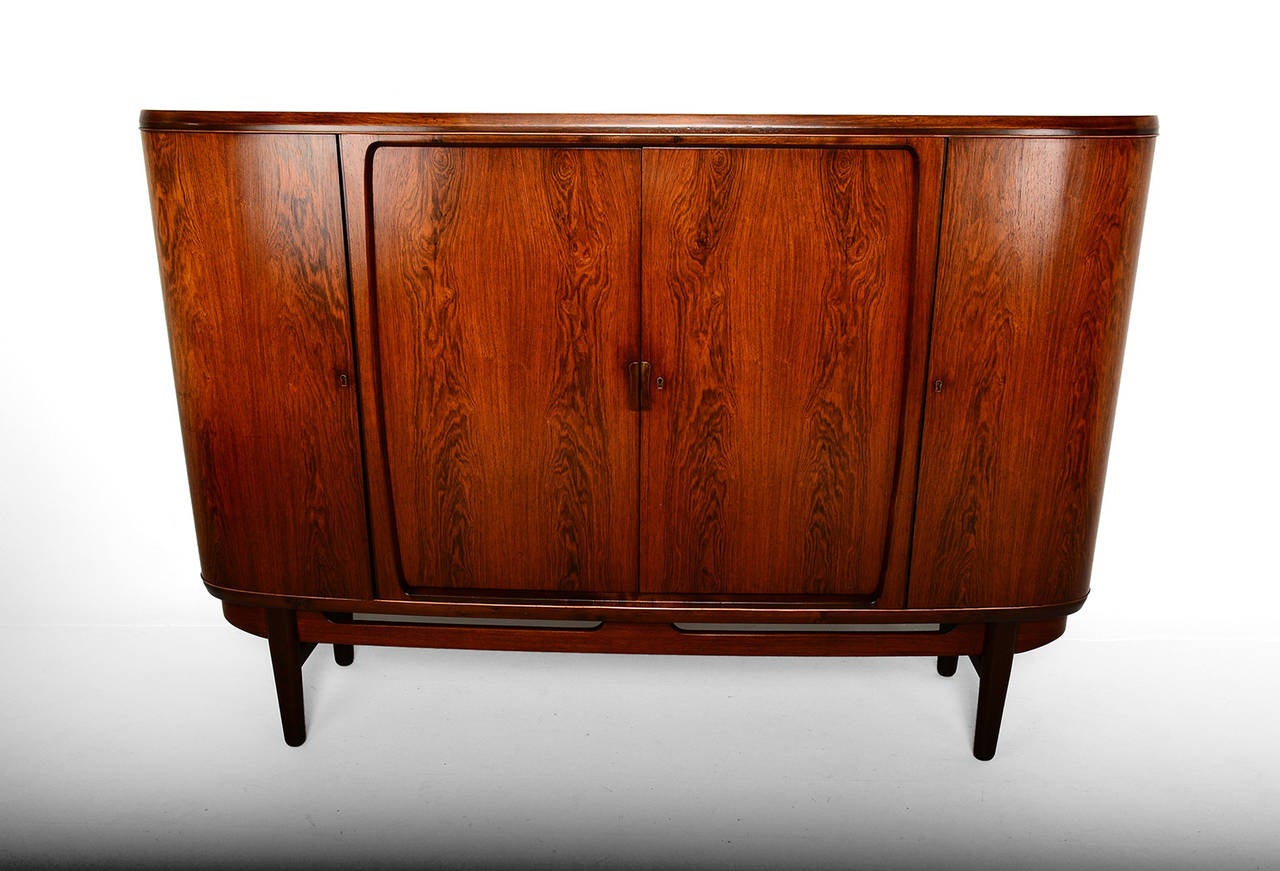 For your consideration a unique and hard to find danish modern credenza/cabinet designed by Bruno Hansen. 
Beautiful rosewood with multiple storage. All drawers open and close. Shelves are adjustable. 
Mounted in peg legs with crossbars to support