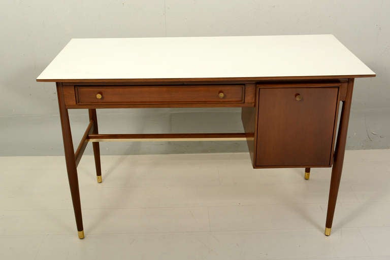 For your consideration a small mid century modern desk. USA circa 50s 
Blond wood finished with walnut tones. White formica top with brass accents. 

 Only two drawers constructed with double dove tail joints.  Drawers open and close with ease.