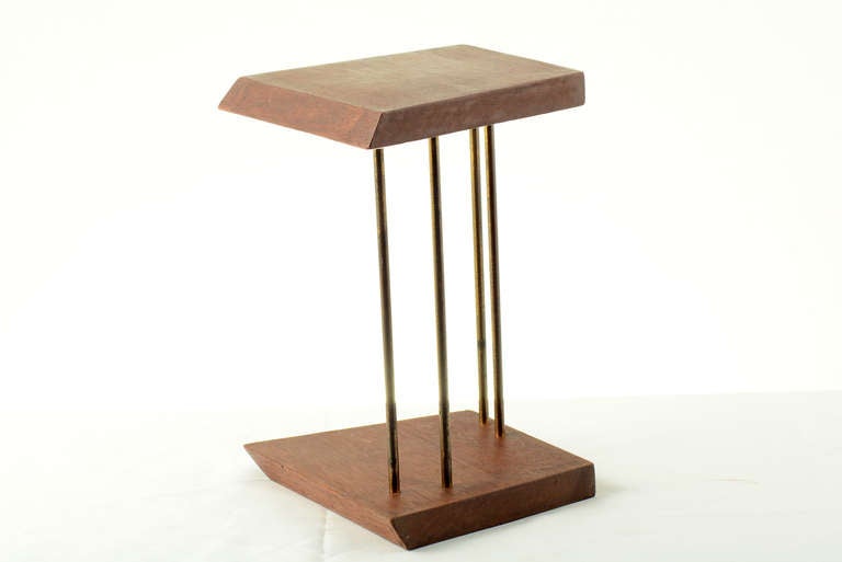 Mahogany And brass table bookend.
Sculptured shape with beveled edge wood. 
Pressed in brass rods with space to fit an assortment of books.
Great tabletop accessory. 

Wood and brass has age and patina.