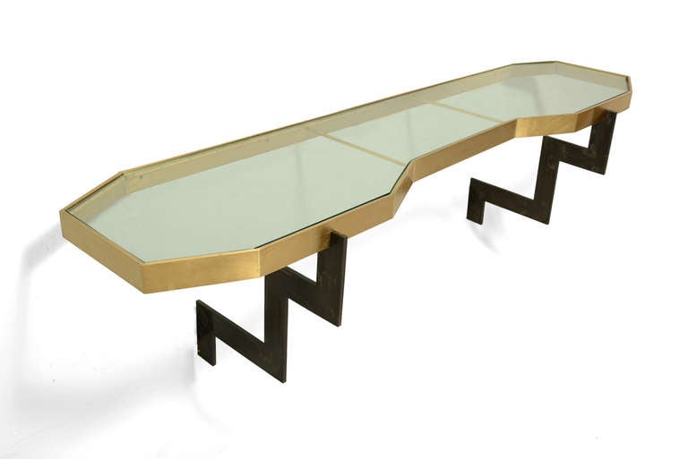 For your consideration a unique console table with sculptural design by Arturo Pani.  Constructed with solid brass  and custom made glass. 

The console is mounted into the wall giving the effect as if it would be floating. 

The wall mounts are