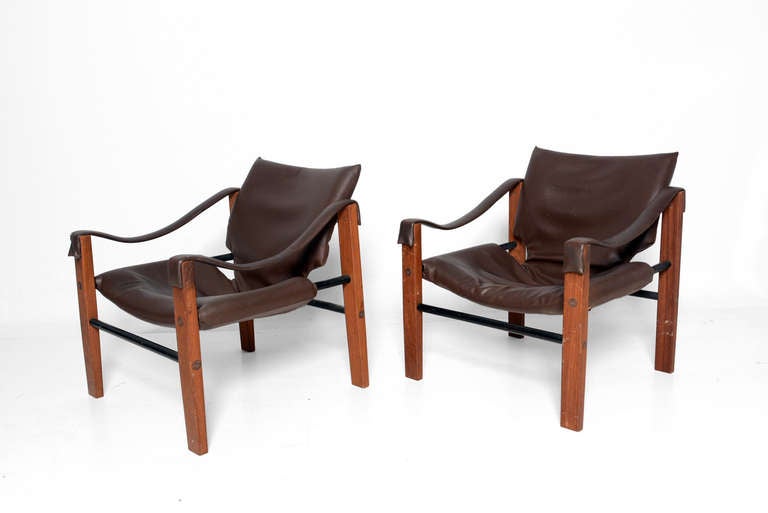 For your consideration a pair of Arkana Safari Chairs designed by Maurice Burke. 

Teak wood frame with black metal frame. Brown faux leather sling.
Backrest has adjustable angle to fits the back in very ergonomic way. Very comfortable seating.