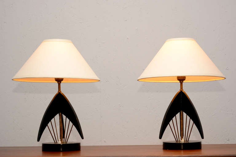 Delightful midcentury sputnik atomic table lamps.
Sculptural Mahogany wood with black lacquer finish stunning brass rods.
Cone shade fits into the bulb. 
Unmarked. Design style after Gerald Thurston and RAAK lighting.
Lamps measures 17.5 Tall x