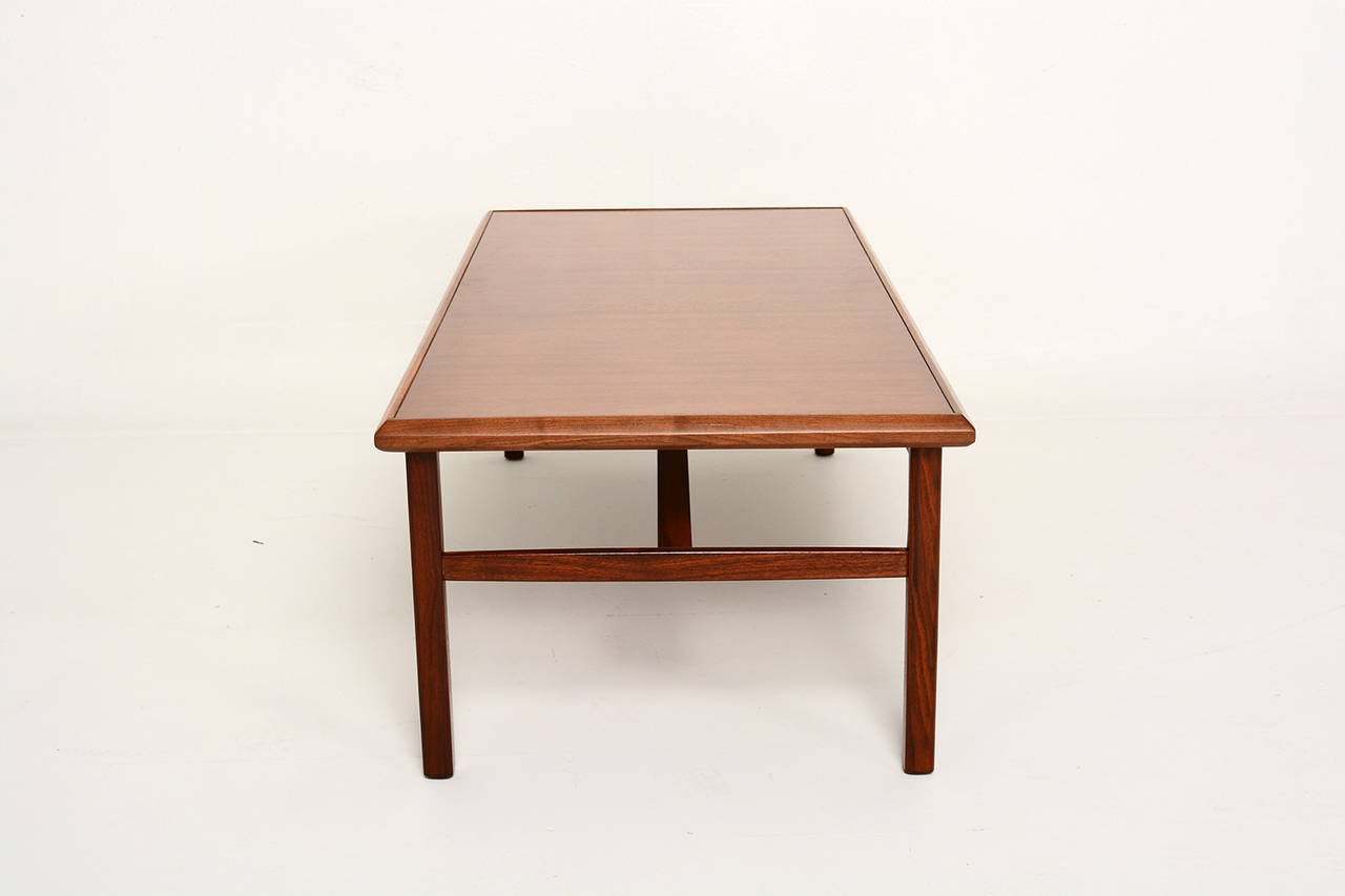 For your consideration a vintage coffee table in walnut wood. 
Legs and sides of the tabletop are made of solid walnut.
Sculptural stretcher adds support to the top. 
Excellent condition, ready to go. 
Rectangular shape.

Unmarked, no information