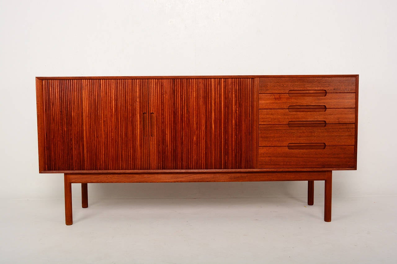 For your consideration a vintage teak credenza by Johannes Aasbjerg.
Solid teak wood with tambour doors on the left side and pull out drawers on the right.
Sculptural built in handles. All drawers are constructed with double dove tail joints.
