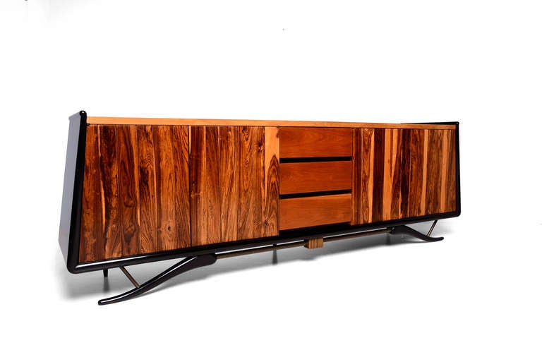 For your consideration a credenza by Frank B. Kyle, in the style of Eugenio Escudero
Constructed with mahogany wood and exotic Cocobolo wood. Sculptural legs on solid mahogany wood finished with high gloss black lacquer. Stretchers in brass with