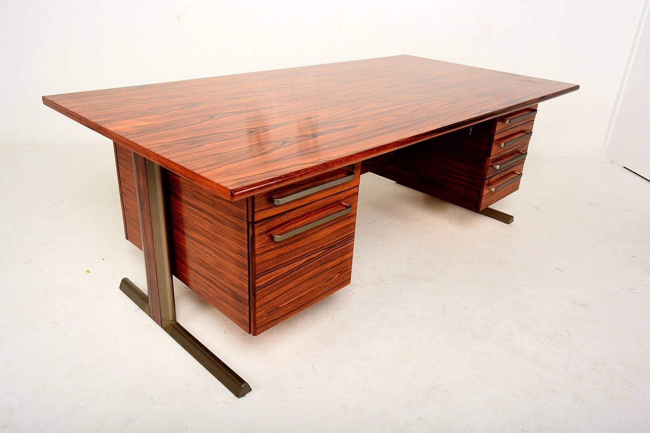 For your consideration a beautiful executive rosewood desk.

Features five small pull-out drawers and one large file drawer.

Sculptural pull handles. 
Knee hole is large to fit most office chairs. Finished on both sides. 
Mounted in solid
