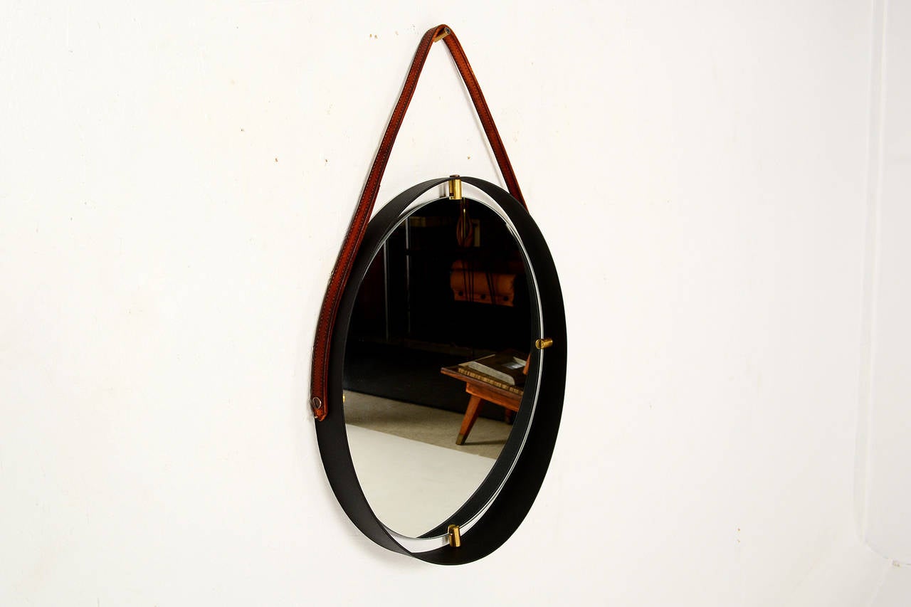 For your consideration a round mirror with metal frame and bronze hardware mounted in nice tan leather strap.

The frame can be finished to meet client’s specifications: unfinished steel, polished nickel, brass or powder coat.

The mirror in