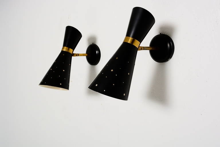For your consideration a pair of vintage sconces constructed with spun aluminium and brass hardware. 

Beautiful double cone shade with laser perforations. 

It has a vintage ceramic socket. No label from the maker present. 
Attributed to