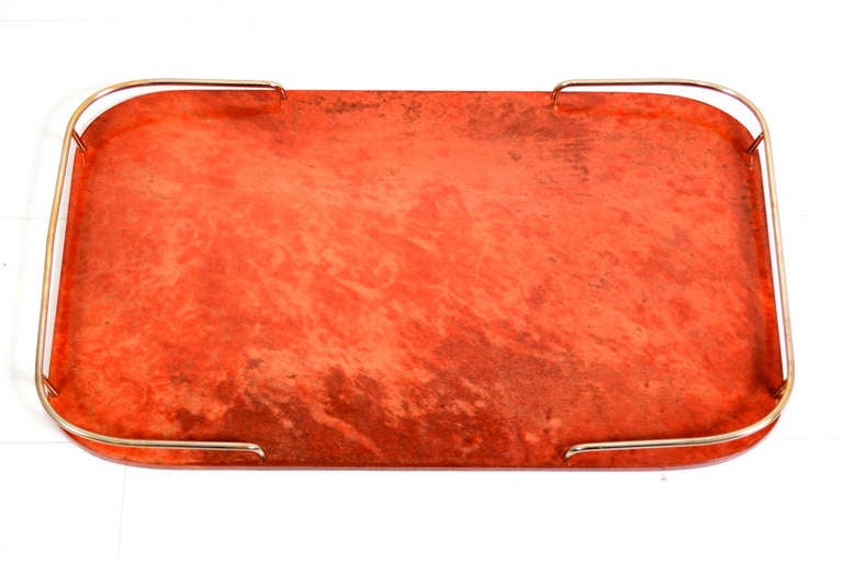 For your consideration a vintage service tray by Aldo Tura. 

Red parchment leather with brass rails in mahogany wood. 

Tray retains partial label from Tura on the back of the service tray.

Rectangular shape with round edges in the corners.