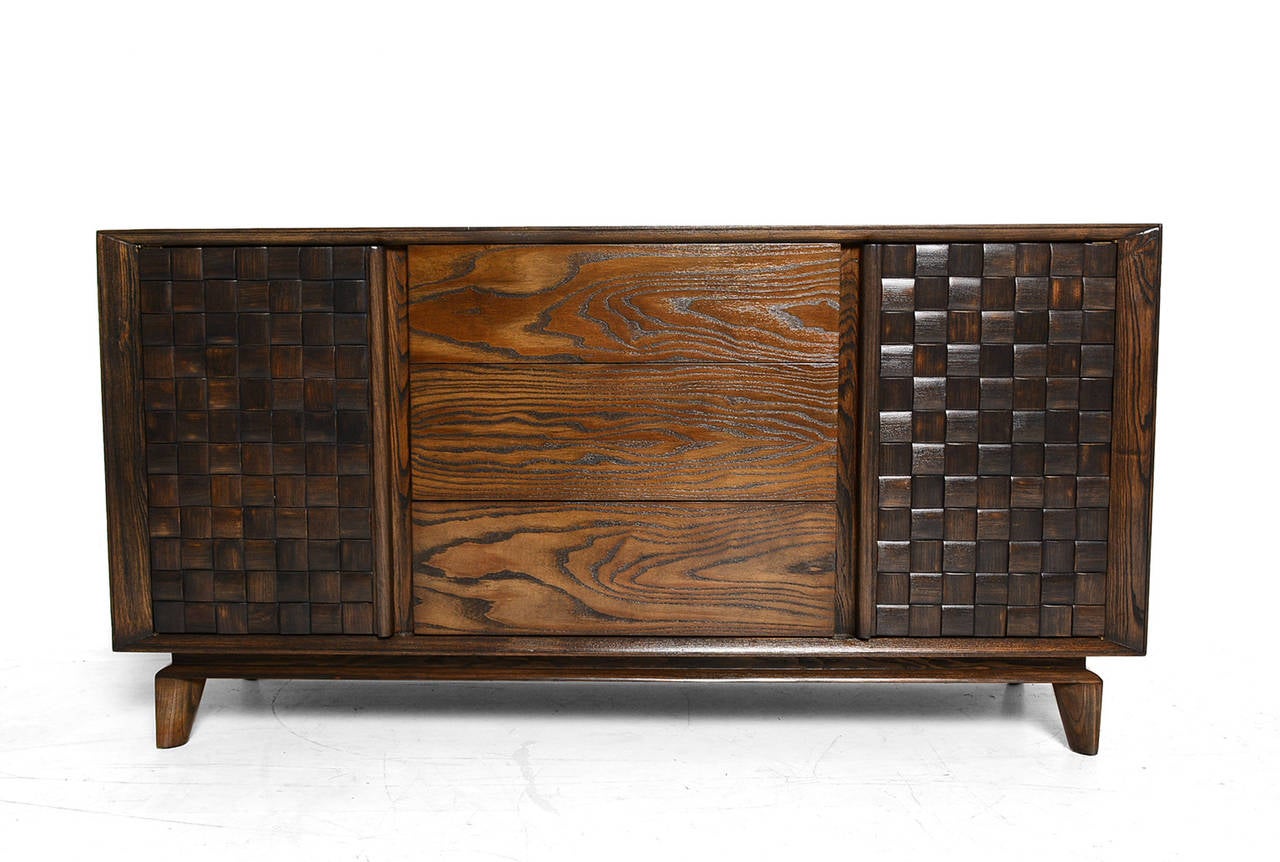 A credenza designed by Paul Laszlo for Brown Saltman. 

Features two open storage with shelves and three pull-out drawers. All drawers are constructed with double dove tail joints and open with ease. 

The top drawer is divided with wood slats.