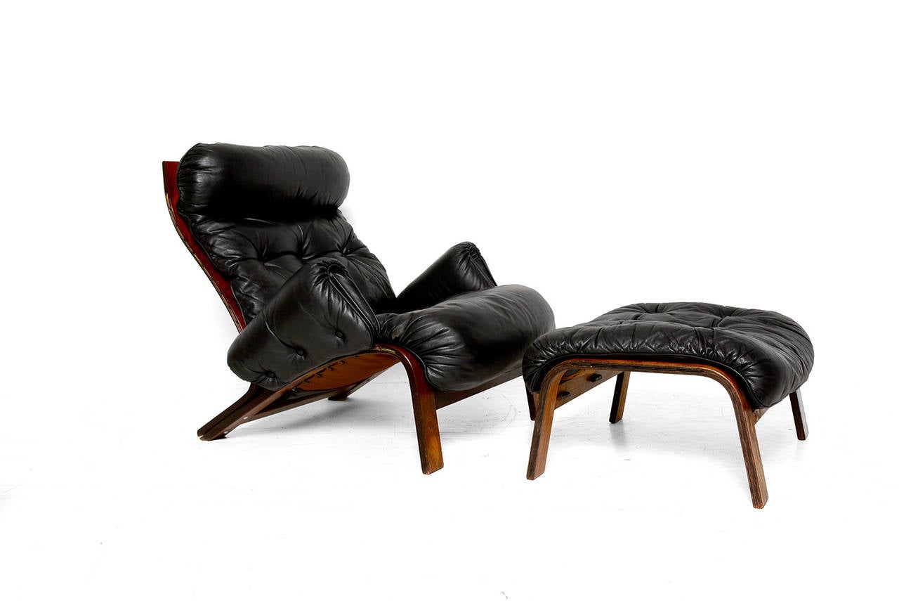 For your consideration a unique lounge chair with matching ottoman. Frame constructed with bent plywood with exotic rosewood veneer. Black leather cushions resting on original canvas. 

No markings from the maker preset. Dated 73 (1973)

Ottoman