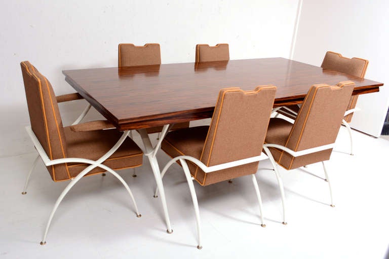 For your consideration a Mid-Century Modern dining set.
Set includes six dining chairs and dining table. 

Dining table has rosewood veneer. The base is sculptural tubular metal frame with tapered legs painted in oyster color and solid brass