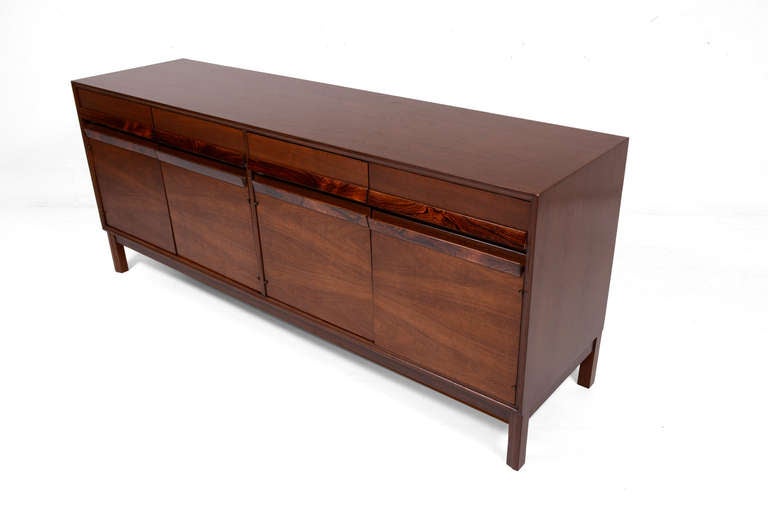 For your consideration a mid-century modern credenza. 

American piece made of walnut wood with rosewood handles. Mounted in solid walnut legs. 

Features four pull out drawers which open and close with ease. All drawers constructed with double