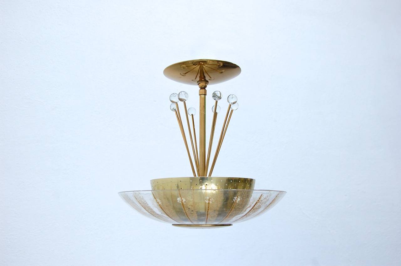 Delightful hanging fixture by Gerald Thurston for Lightolier in patina brass and glass.
