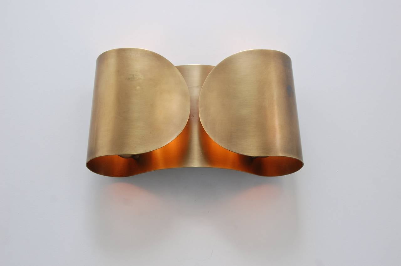 Modern and sleek pair of Foglio sconces by Tobia Scarpa in a patina brass un-lacquered finish.
(2) E26 medium based sockets/lightbulbs per sconce. 