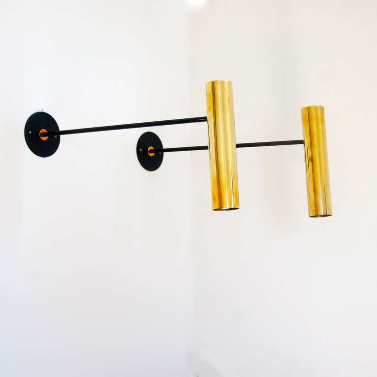 Sleek directional sconces by Boris Lacroix. Stem is fixed yet the brass shades move up and down, sideways and rotate in all directions. They are finished in an un-lacquered brass. Boris Lacroix was a French avant-garde designer influenced by fashion