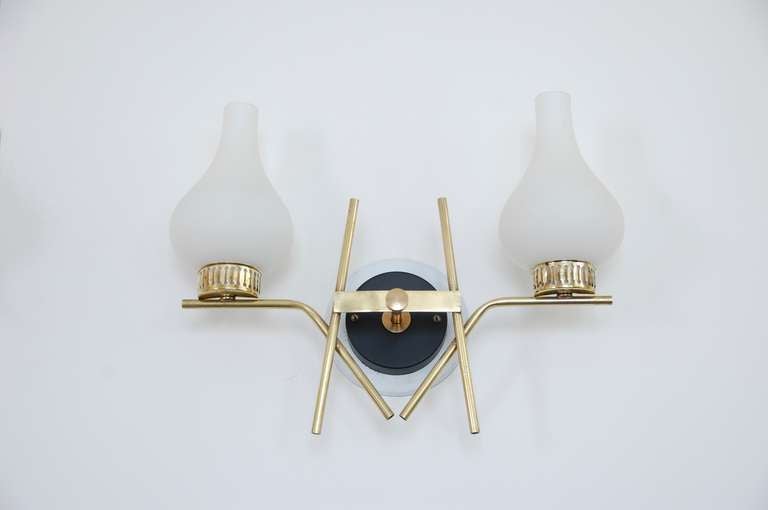 Quaint pair of Mid-Century Italian Sconces. Although they posses a geometric modern character, these sconces have a slight adornment in the glass and the glass holders, making them suitable for a particular themed environment, as well as for simple