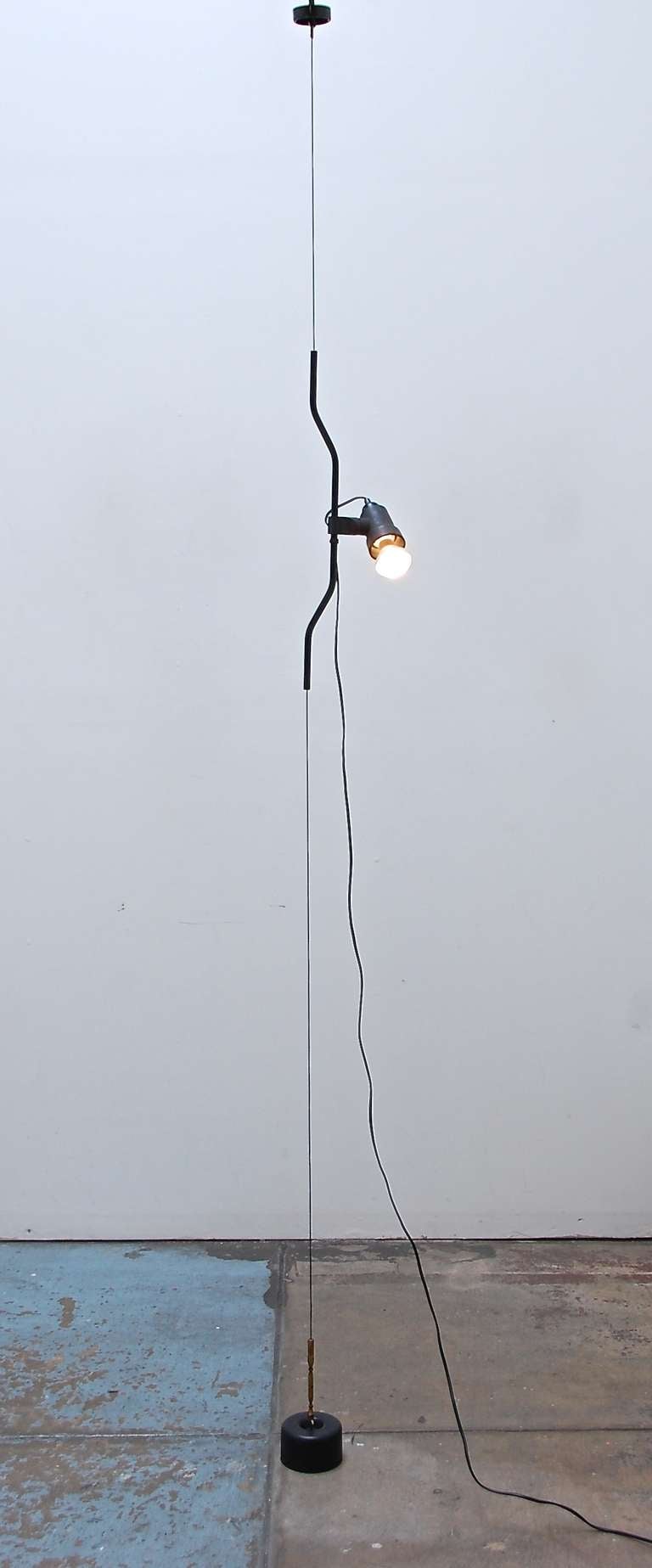 Achille Castiglioni & Pio Manzu designed “Parentesi” ceiling to floor suspension lamp for Flos from Italy. This unique fixture is part of the permanent collection at MOMA. The directional light swivels and is height adjustable.