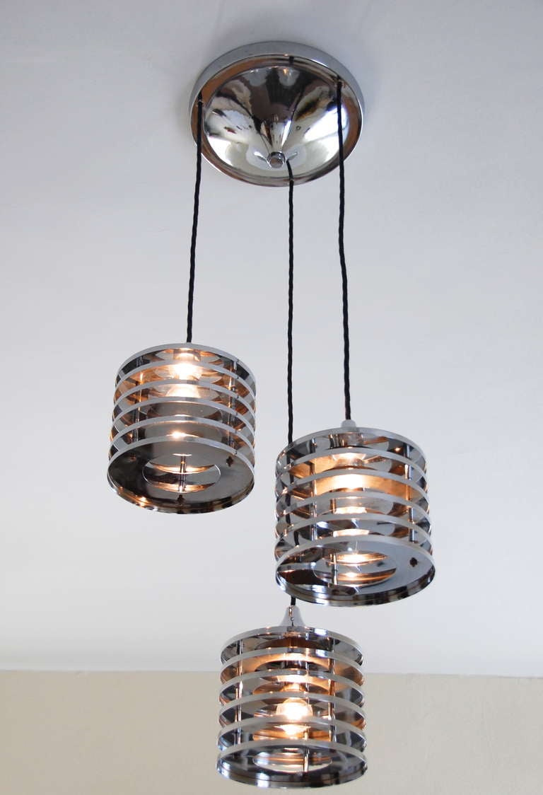 A modern take of a 1920s lampshade concept. This 60s Italian chandelier looks strikingly contemporary 50 years later. 
Properly cleaned, new wires and sockets. Adjustable drops. The 3 shades can be also used as individual pendants.

Drop: