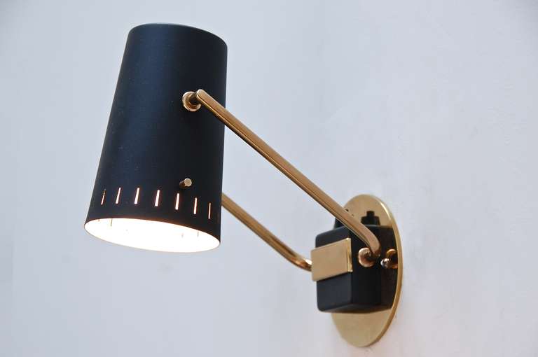 Fantastically versatile articulated reading sconces from Germany in painted black aluminum and patina brass. Shades have a lovely range of motion for directional use.

Shade dimensions: 5