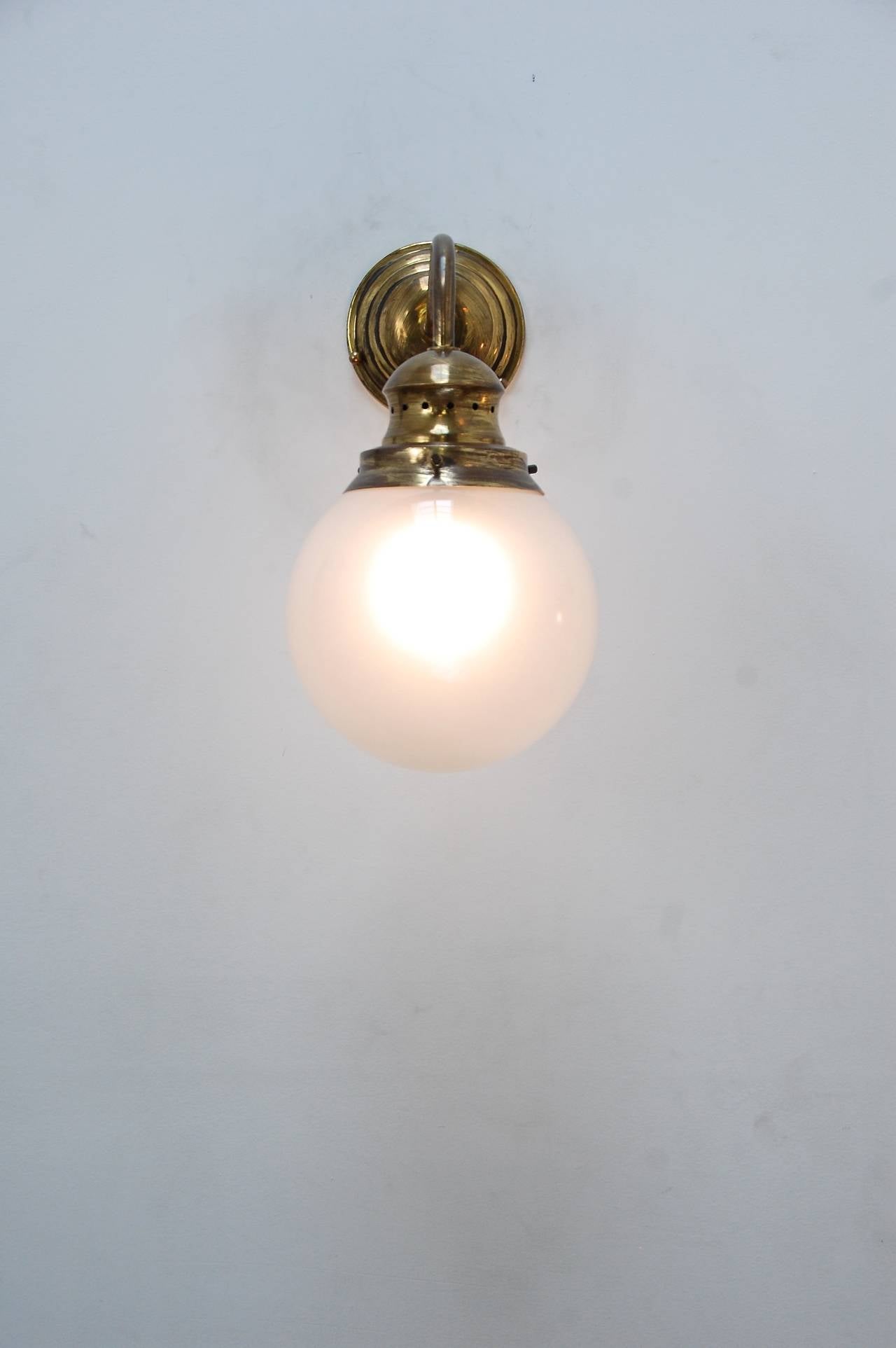 (Five) Italian wall lights designed by Luigi Caccia Dominioni for Azucena in naturally aged and glass globe frosted inside. 

We are aware that they are commonly used in a reversed position than what is displayed.

Priced per sconce: $1200.