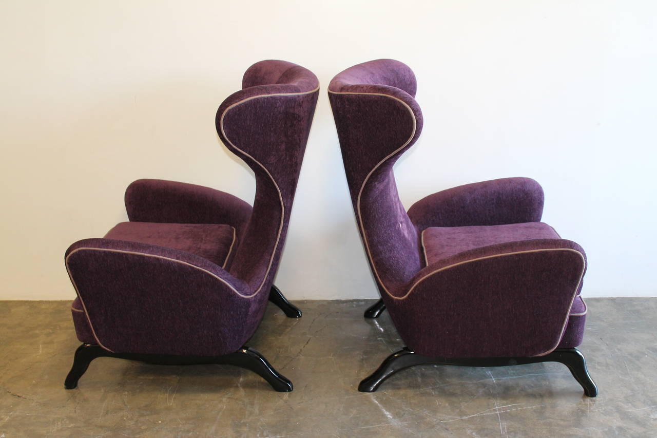 Pair of highly stylized 1950s Italian sculptural wingback lounge armchairs.
Unknown designer, completely restored.
Beautiful lines, angles and large-scale.
Black lacquered walnut bases.