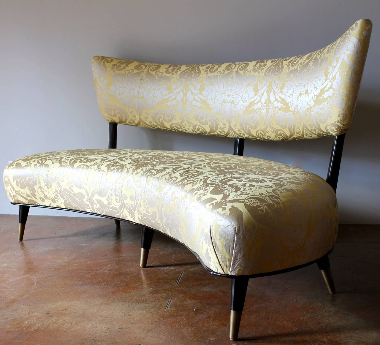 Sophisticated, elegant shape, 1950s Italian floating, curved sofa.
Large-scale.
Completely refurbished, reupholstered in fine silk fabric.
Beautiful sculptural legs with long brass sabots.