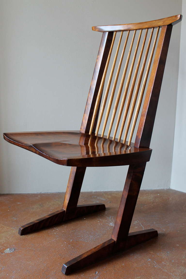 Iconic conoid chair. 
Designed by famed architect or wood master George Nakashima.
American black walnut with hickory spindles.
New hope, Pennsylvania, circa 1970.
Manufactured by Nakashima Studio. (Provenance on request).
Literature: George