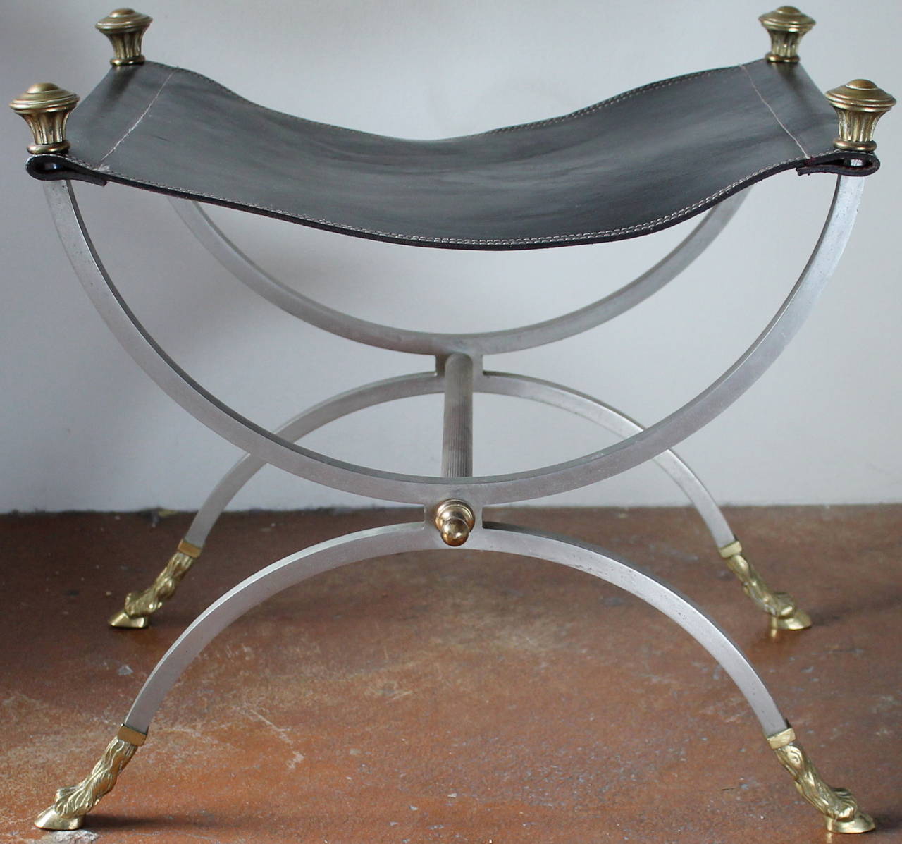 A chic pair of two stools in brass and steel with black leather seats in the style of Maison Jasen.
brass hoofed feet.
Made in Italy in 1970s.