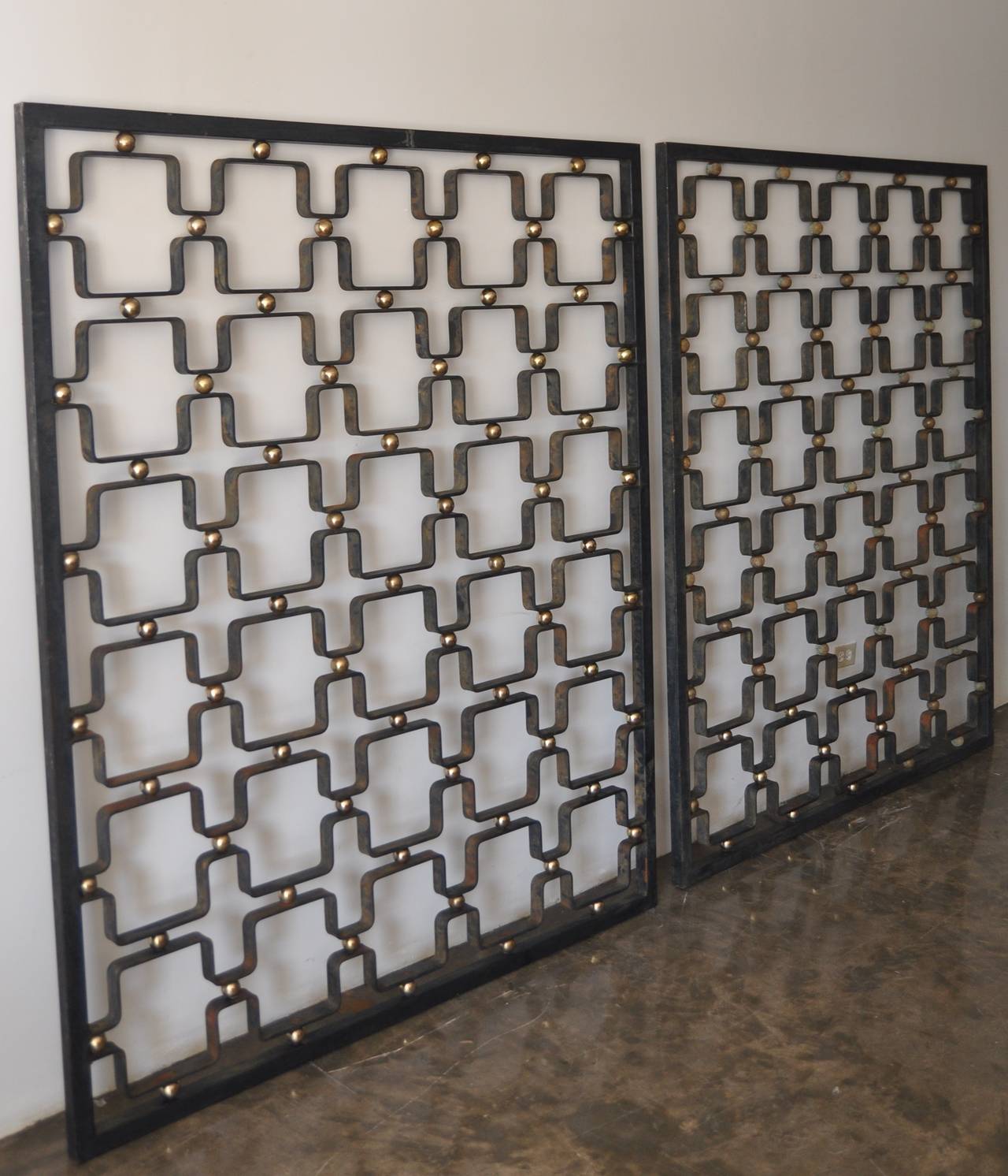 A pair of wall screens / room dividers of wrought iron with solid brass balls detailing in a Classic Royère pattern. This screen can be used either vertically or horizontally. Please see the book 
