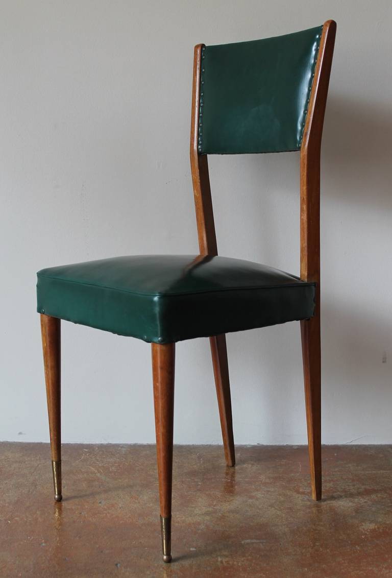 Italian set of six 1950s mahogany dining chairs in the style of Gio Ponti.
Beautiful original condition.
Nice original brass front sabots.
Clean lines and solid mahogany construction with original leatherette upholstery. An unusual set of chairs